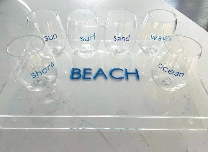 personalized 11" x 14" clear acrylic tray with vinyl BEACH in the center and 6 stemless wine glasses with fun beachy sayings